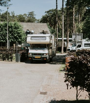 Een camper rijdt weg bij een vakantiepark