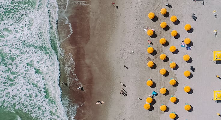Zee en strand met gele parasols, van bovenaf gezien