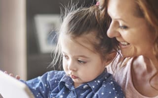 Een vrouw met haar kind, die samen bezig zijn met een tablet
