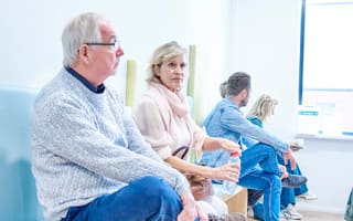 Een man, vrouw en twee andere mensen die in de wachtkamer van een zorginstelling zitten