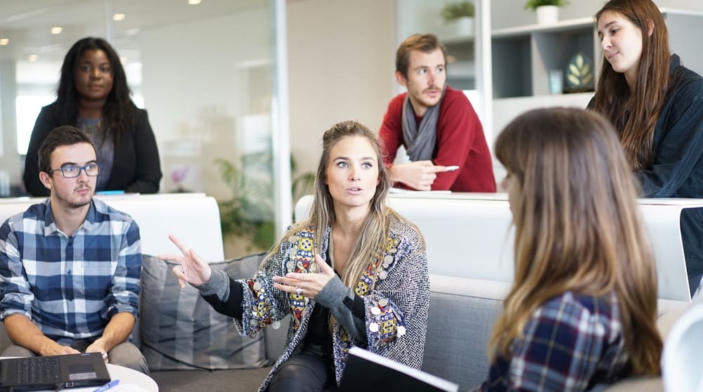 Zes mensen die met elkaar in gesprek zijn over verzuim
