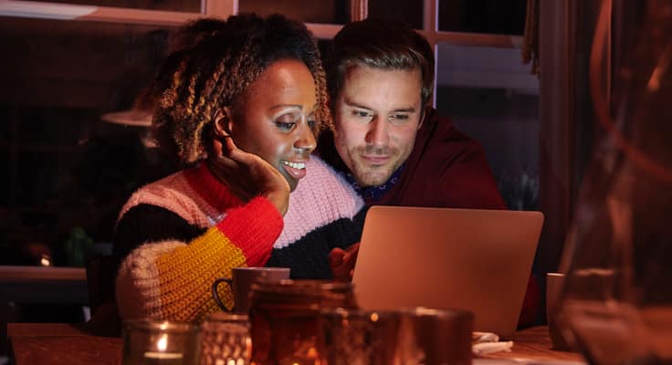 Een man en een vrouw die achter een laptop hun verzekeringszaken regelen