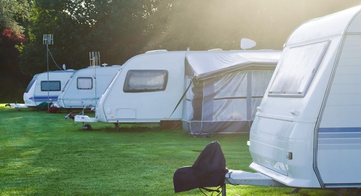 Caravans op een camping in een bosrijke omgeving. Met de Caravanverzekering van Interpolis kunt u uw caravan verzekeren tegen schade en diefstal.