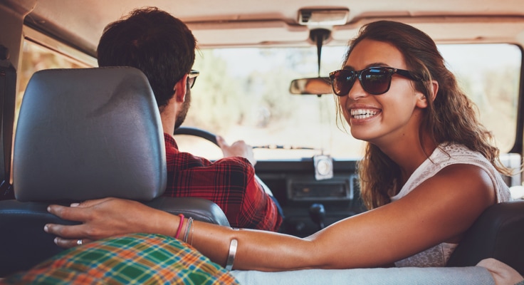 Een man en vrouw zitten in een auto. De jonge vrouw kijkt om terwijl de man rijdt. Met de aanvullende dekking inzittendenverzekering van Interpolis verzekert u uw passagiers voor materiële schade en letselschade bij een ongeluk.