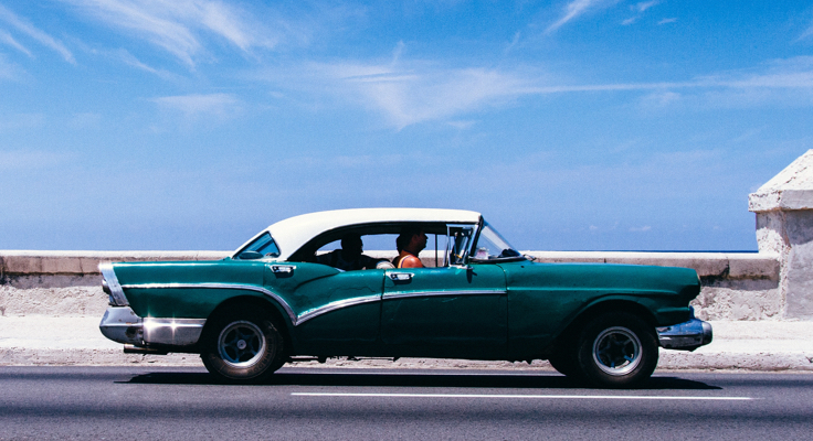 Rijdende oldtimer op weg. Met de Oldtimerverzekering van Interpolis kunt u uw klassieke auto verzekeren tegen schade en diefstal.