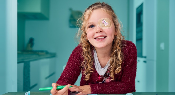 Lachend meisje zit te kleuren aan een keukentafel. Met de GebitActief Tandverzekering van Interpolis kunt u uw tandartskosten verzekeren naast uw ZorgActief basisverzekering van Interpolis.