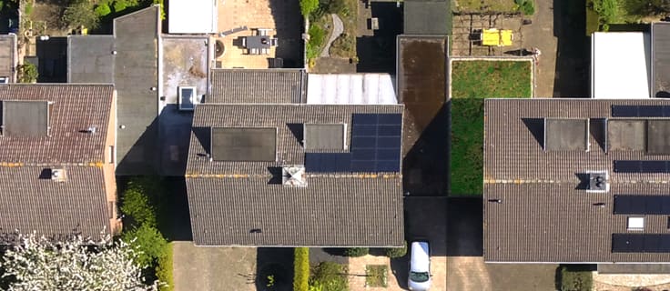 Bovenaanzicht van een woonwijk met groene daken