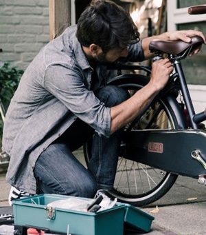 Een man is een fietszadel aan het verstellen