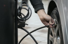 Iemand die een autoband op de juiste spanning zet