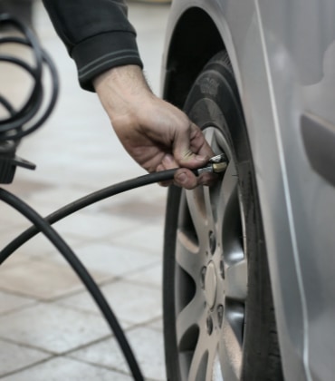 Iemand die een autoband op de juiste spanning zet