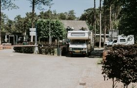 Een camper rijdt weg bij een vakantiepark