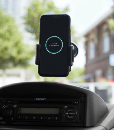 De AutoModus app van Interpolis in een telefoonhouder in een auto