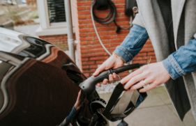 Het inpluggen van de oplaadstekker van een elektrische auto.