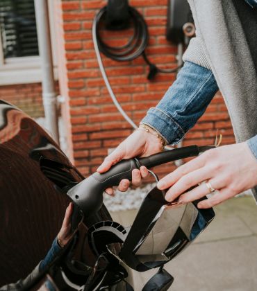 Het inpluggen van de oplaadstekker van een elektrische auto.