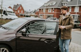 Een man heeft zijn autoportier open en staat op het punt om in te stappen