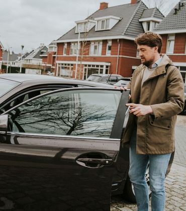 Een man heeft zijn autoportier open en staat op het punt om in te stappen