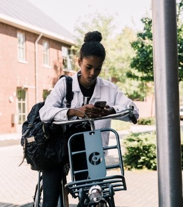 Jonge fietser kijkt op haar telefoon