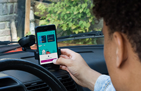 Een man achter het stuur van zijn auto zet de AutoModus app aan voordat hij gaat rijden.