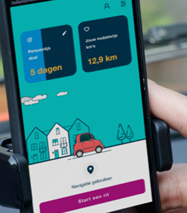 De AutoModus-app op een mobiele telefoon die in een voorruithouder bevestigd is.