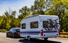 Auto met caravan achter rijdt op de snelweg.