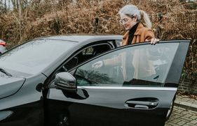 Vrouw stapt in de auto. Hoe voorkomt zij een verkeersboete?