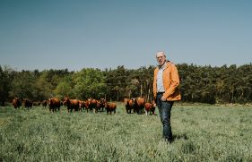 Eigenaar Johan Martens staat voor zijn koeien op het terrein van zorgboerderij Hemelrijksche Hoeve.