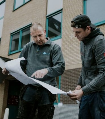 2 mannen bekijken bouwplan. Wist je dat Interpolis je een bouwadvies kan geven? 