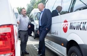 2 mannen in overleg staand tegen taxi van Munckhof