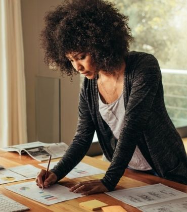 Vrouw staat aan haar bureau te werken