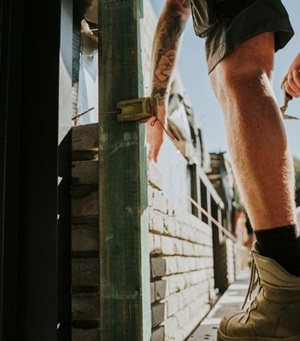 Schoenen van een bouwvakker naast een muurtje dat hij bouwt