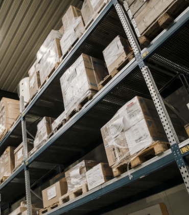 Magazijnstellingen in een bedrijfshal met daarop pallets.