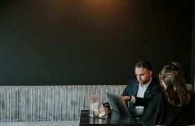 Man en vrouw in overleg achter laptop