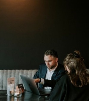 Man en vrouw in overleg achter laptop