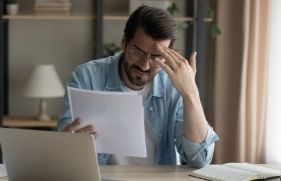Man achter laptop leest iets wat hem bezorgd maakt