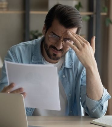 Man achter laptop leest iets wat hem bezorgd maakt