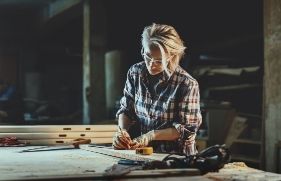 ZZP'er meet de lengte van een plank om te bewerken in de werkplaats