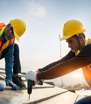 2 mannen met helm op aan het werk in de bouw