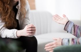 Handen van 2 mensen die met elkaar in gesprek zijn