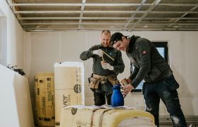 2 jonge mannen lachen en drinken koffie op de bouw.