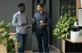 Mannen overleggen aan de koffieautomaat