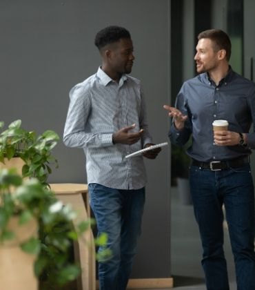 Mannen overleggen aan de koffieautomaat