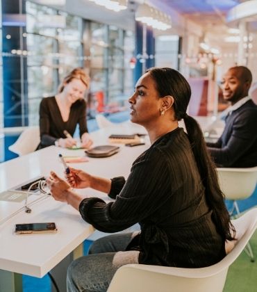 Collega's op kantoor praten met elkaar. Ziekteverzuim is dit jaar met 50% gestegen. 