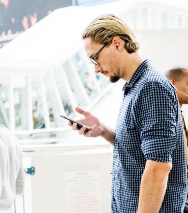 Man kijkt naar de mobiele telefoon in zijn hand