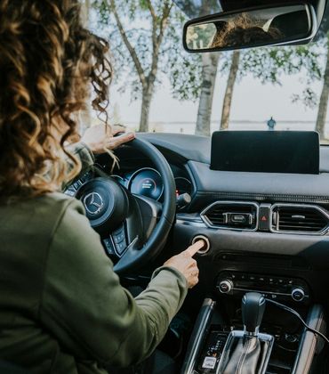 Vrouw zit in auto en start de auto