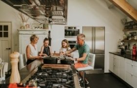 Gezin met 2 kinderen eet aan de keukentafel