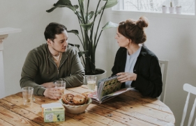 Een man en een vrouw zitten aan een ontbijttafel.