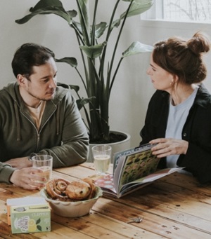 Een man en een vrouw zitten aan een ontbijttafel.