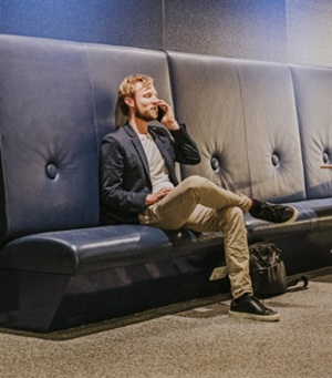 Een man zit bellend op een bankje