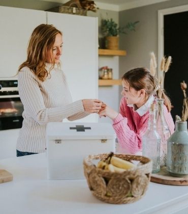 Moeder doet dochter een pleister om de vinger