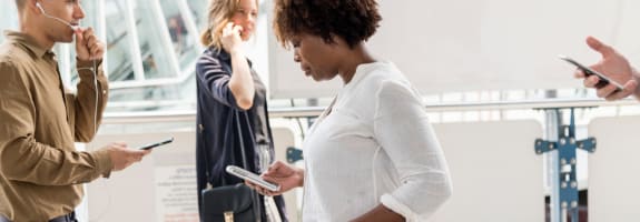 Een vrouw die op haar smartphone kijkt en een vrouw die aan het bellen is